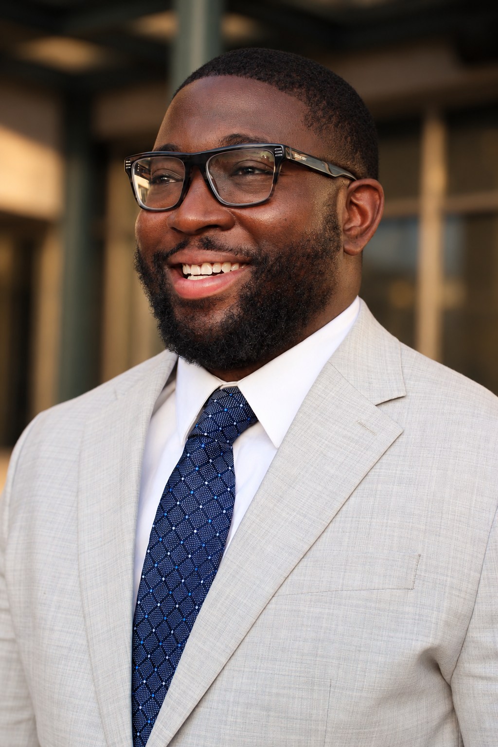 Smiling professional portrait in a light suit and navy tie