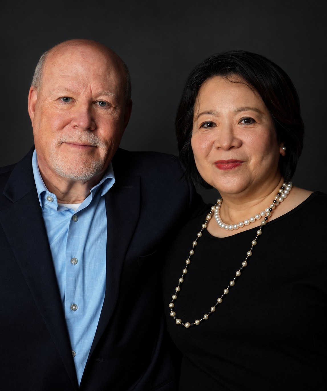 Studio portrait of two people seated closely together