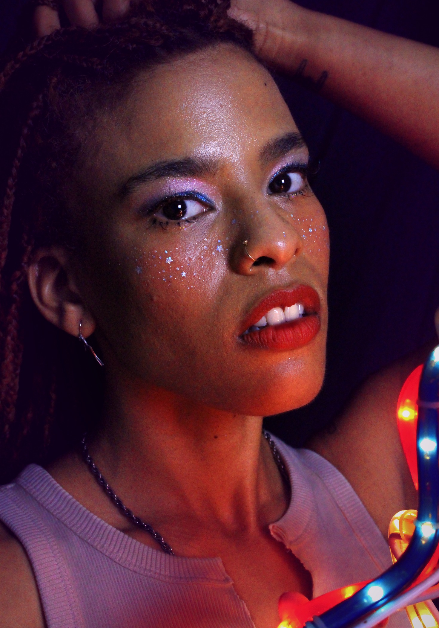Close portrait with sparkling violet makeup and colorful lights