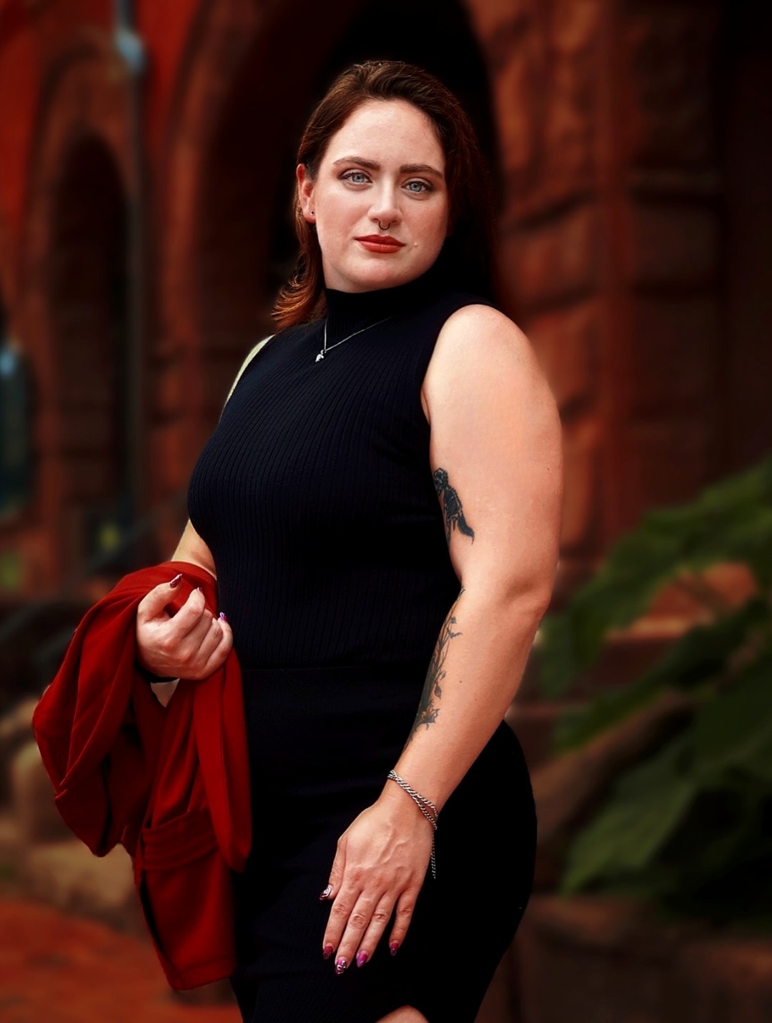 Portrait in a black dress against red brick architecture