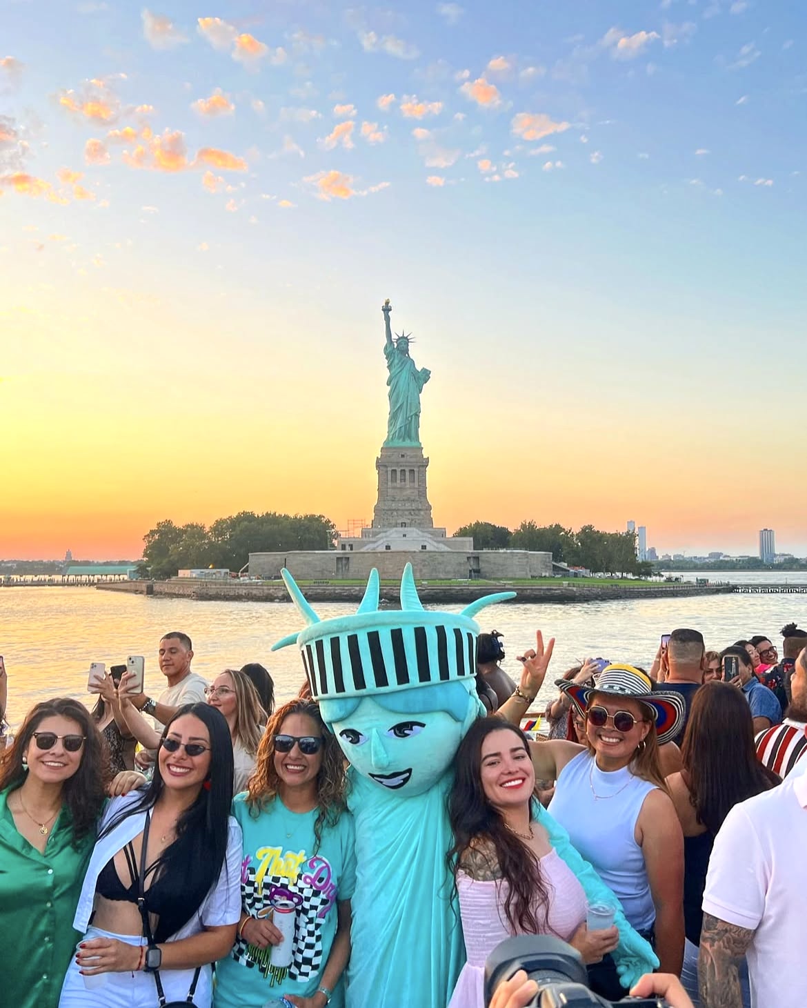 Celebration aboard a boat near the Statue of Liberty at sunset