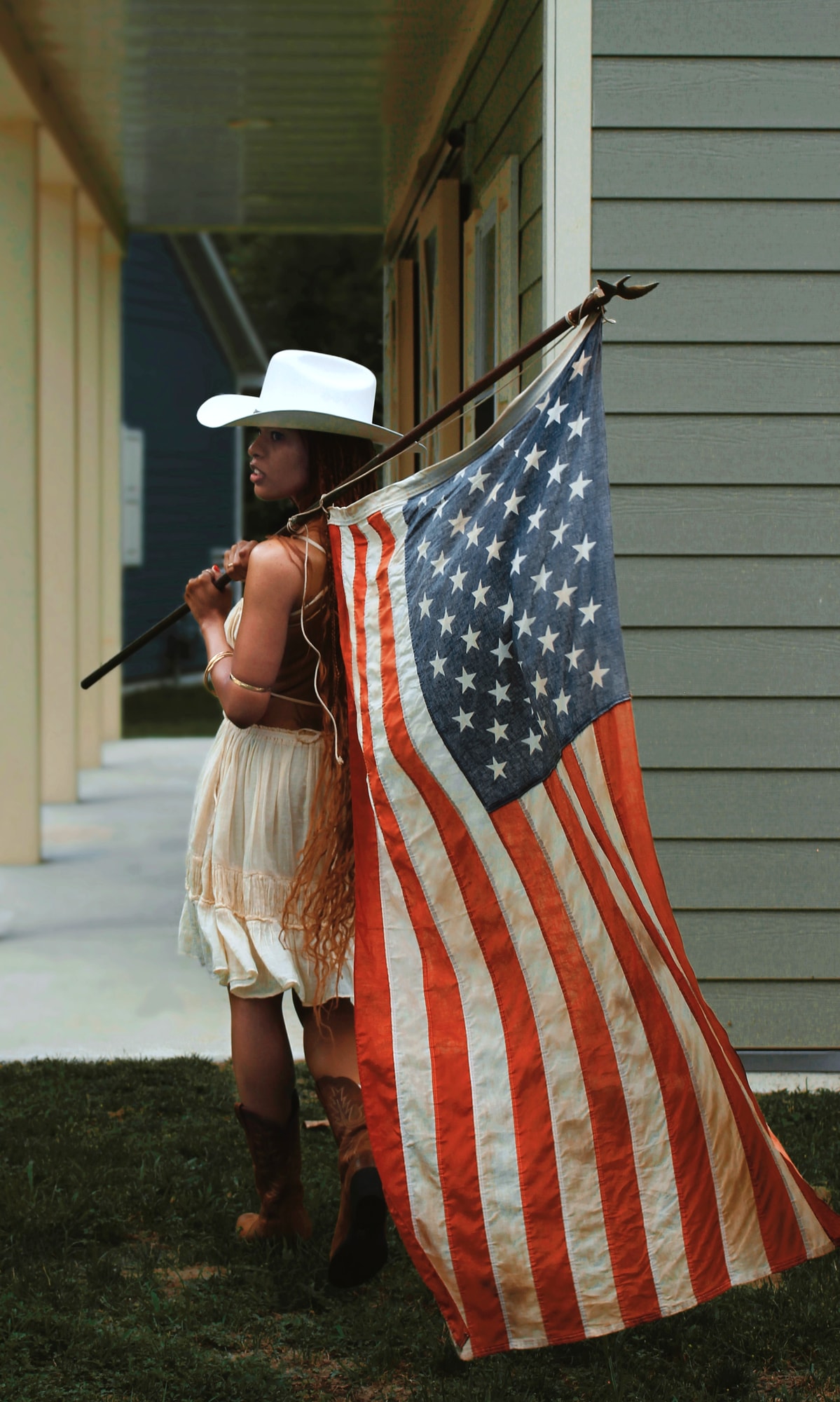 Portrait on a shaded porch holding an American flag