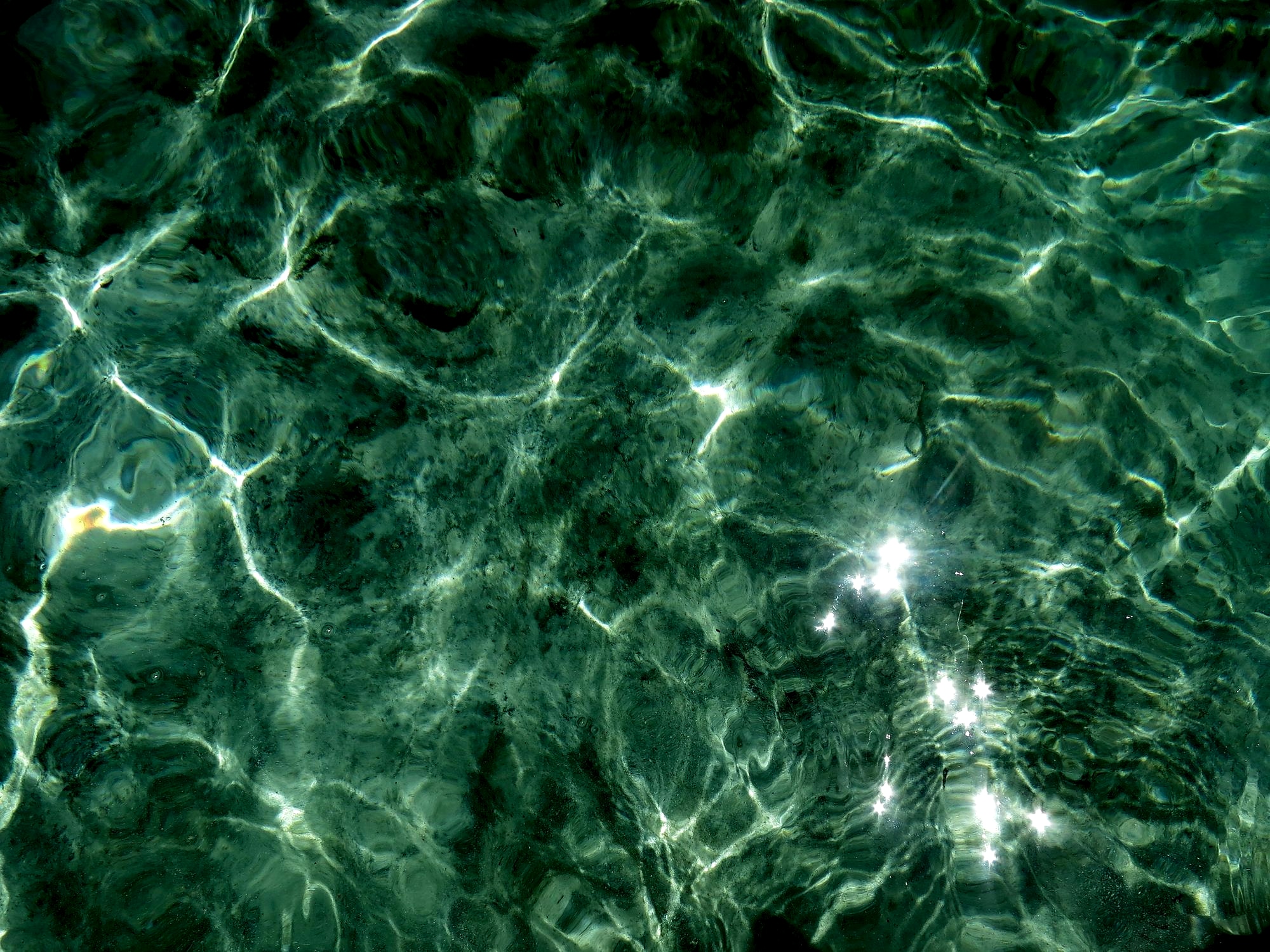 Soft green water with intricate reflected sunlight