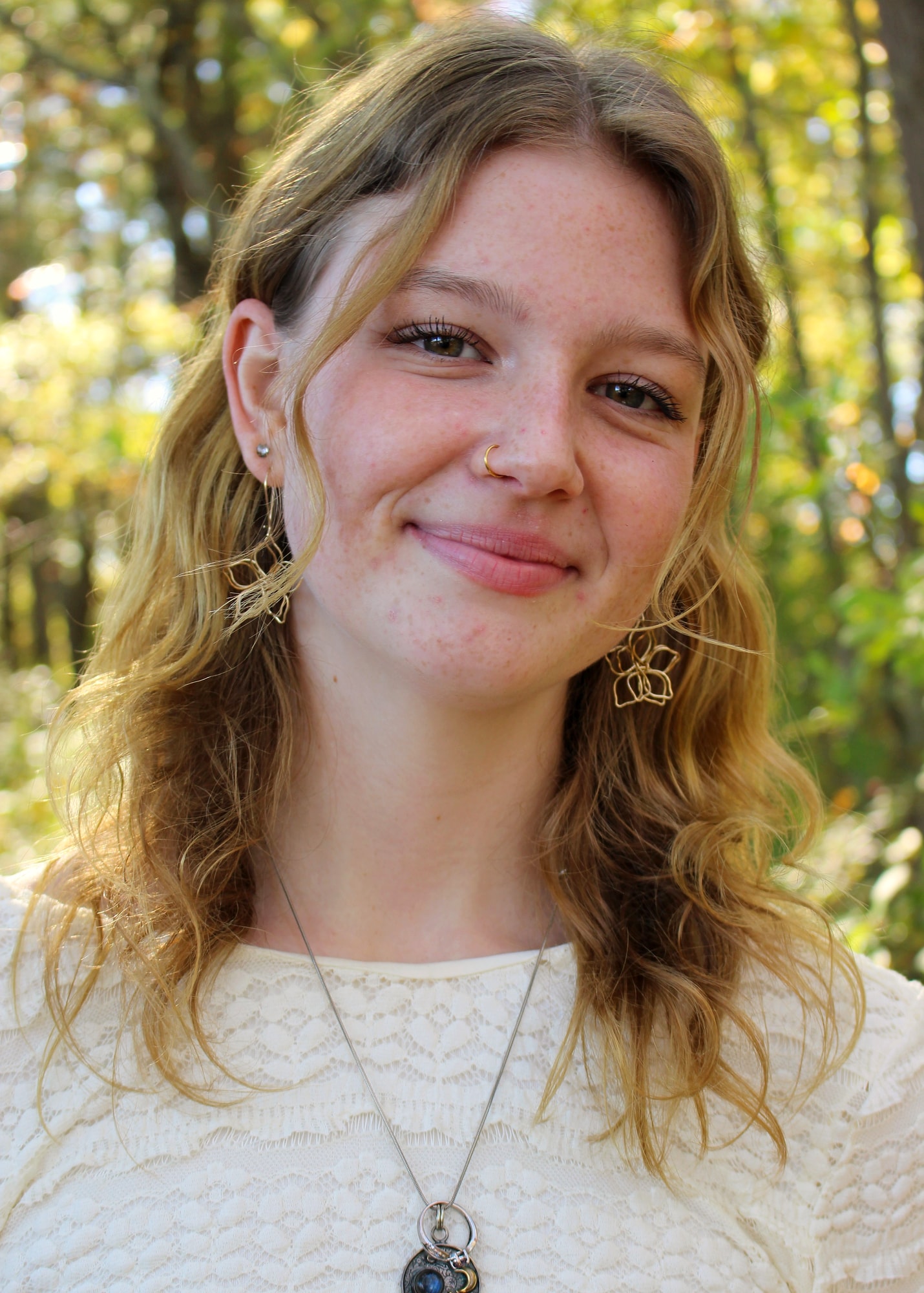Portrait in a cream top in softly lit autumn woodland