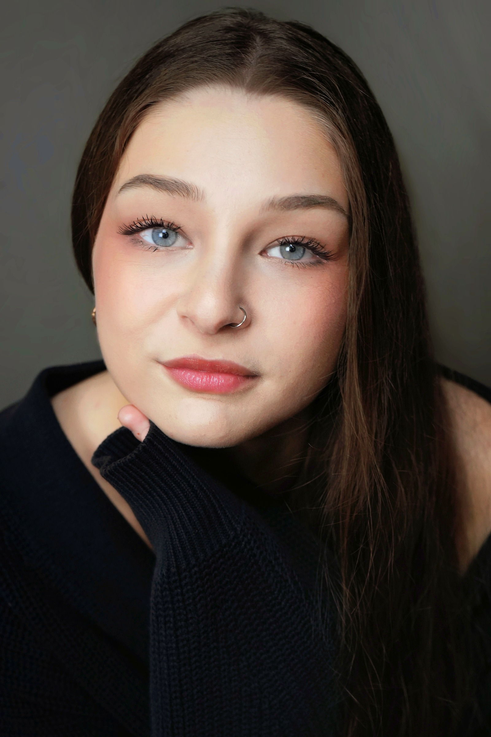 Close-up studio portrait with soft light and a charcoal background
